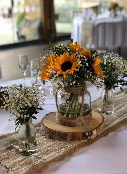 a triple rustic wedding centerpiece of vases with baby's breath and sunflowers is a gorgeous idea for a bright summer wedding in rustic style