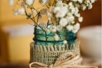 a turquoise jar with burlap and yarn, with baby’s breath is a lovely and simple rustic wedding decoration to rock