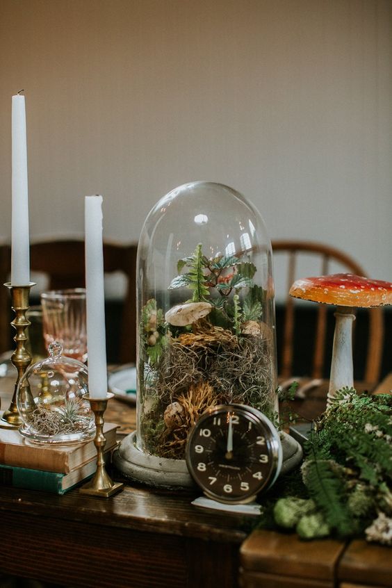 a woodland wedding centerpiece of a cloche with moss, greenery and mushrooms is amazing