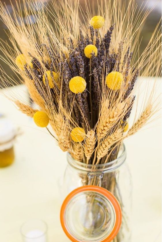 wheat, lavender and craspedia arrangement in a jar won't break the bank and will add a rustic touch to the space