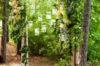 04 candle lanterns hanging on a birch and flower arch