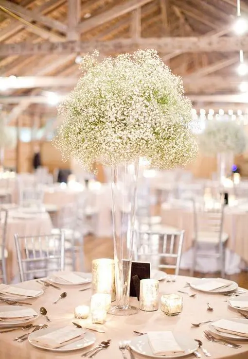 a tall cone glass vase with baby's breath is a great fit for many wedding styles