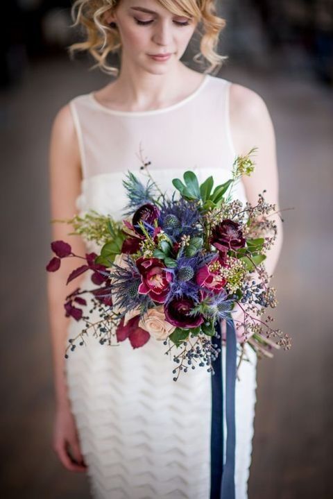 a wedding bouquet with thistle, burgundy and purple blooms