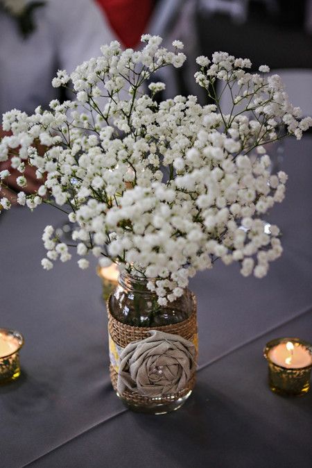 a jar wrapped with burlap and with a fabric flower and baby's breath