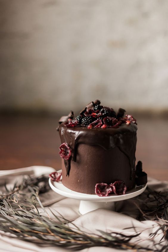 chocolate wedding cake with chocolate drip, blackberries, pomegranates and sugared flowers