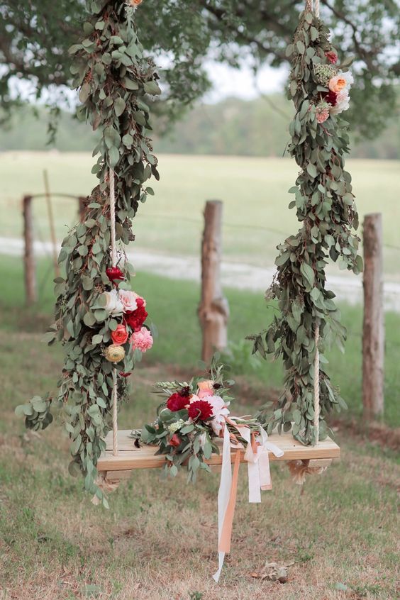 a lush deccorated swing with leaves and bold flowers