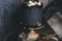 07 a matte black wedding cake with black drip, cream, gilded blackberries and chocolate on top