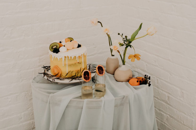 The dessert table with ethereal fabric and orange flowers