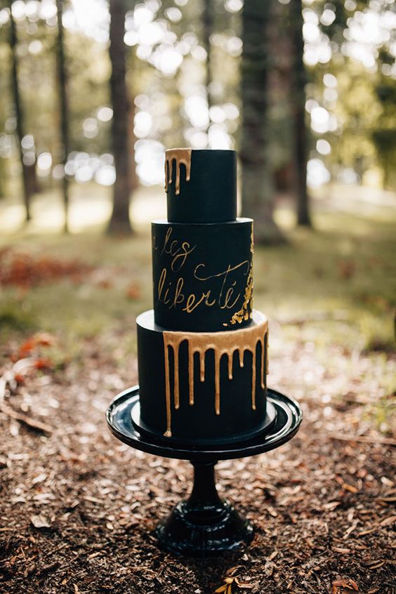 black wedding cake with copper drip and calligraphy