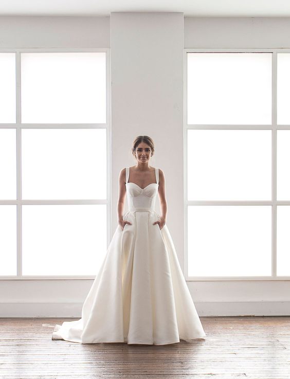 modern wedding dress in cream with a bustier and a full skirt with pockets