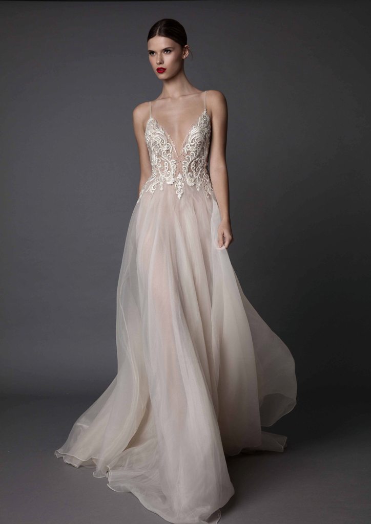 blush wedding dress with spaghetti straps and a lace applique bodice, a flowy skirt