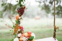 11 a swing decorated with lush fall-themed flowers and greenery