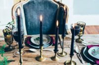 11 black candles in gold candle holders, exquisite glasses and moody florals for the refined tablescape