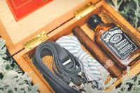 12 a box with a bow tie, suspenders, whiskey and a cigar is eveyrthing that a groomsman needs