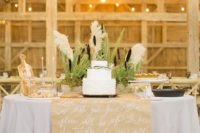 13 The cake table decorated with a paper runner and some greenery