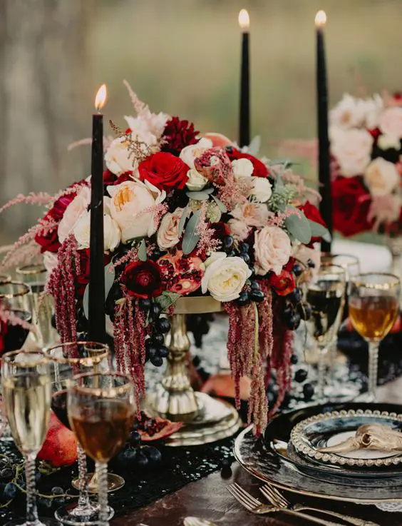 decadent tablescape with a burgundy centerpiece with pomegranates and dripping amaranthus