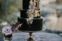 17 black iced wedding cake with gold detailing and fresh flowers