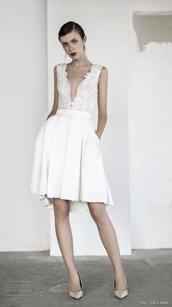 short wedding dress with a lace plunging neckline bodice and a pleated skirt with pockets