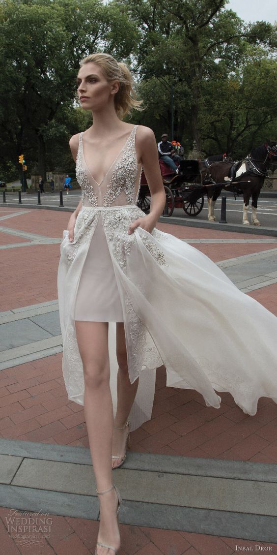 ivory deep V neckline heavily embellished wedding dress with an overskirt and pockets