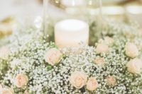 19 a baby’s breath and blush roses wreath with a large glass candle holder