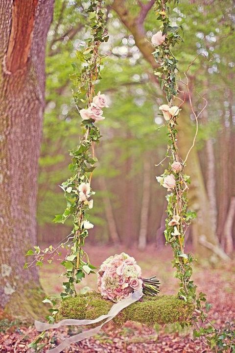 garden-inspired swing with pink roses, vine and a moss covered seat