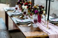 20 pastel-colored wedding tablescape with a powder pink table runner and blue napkins, jewel tone florals and black candles