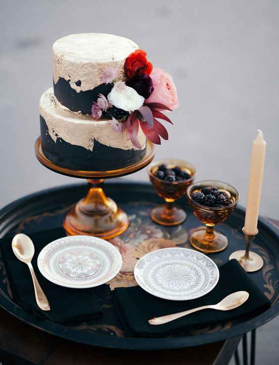 matte black and silver leaf cake with lush fresh blooms and berries