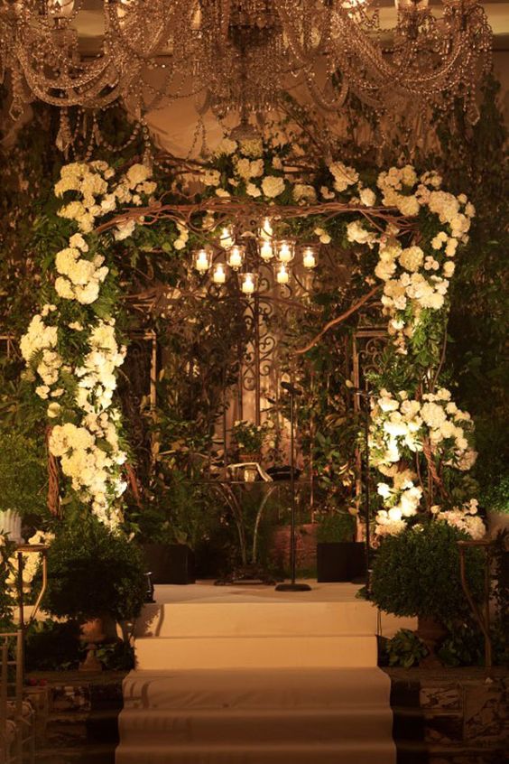candle holders hanging over the wedding arch for soft romantic light
