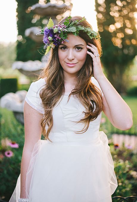 greenery crown with wax flowers and a bold purple bloom on the side