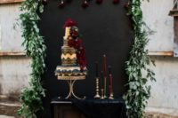 26 decadent cake table with black fabric, candles and red roses dripping on the backdrop