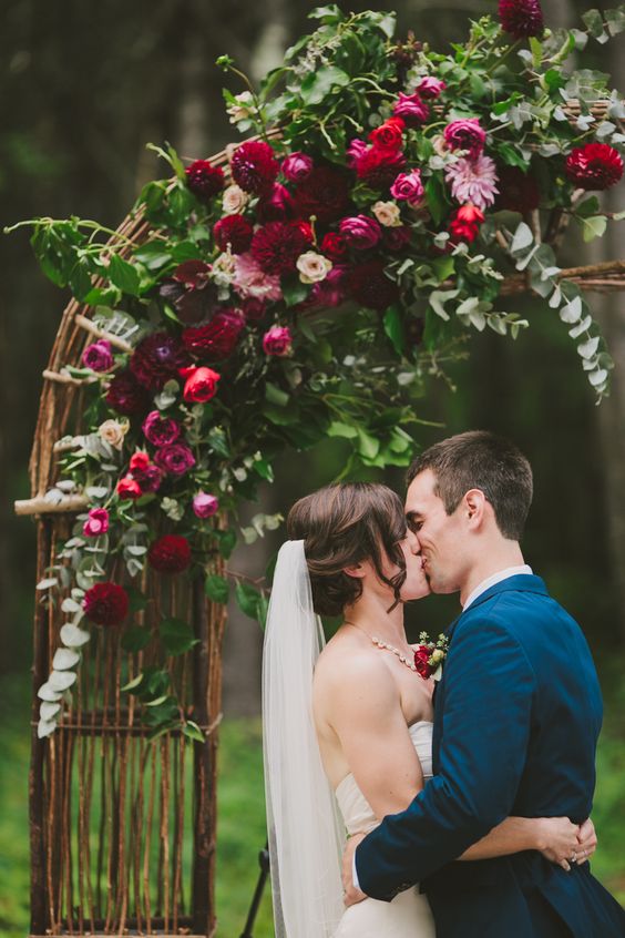 hot red and pink and burgundy flower wedding arch with eucalyptus