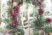 31 lush greenery wedidng arch with fuchsia, violet and burgundy blooms