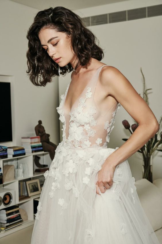 A chic A line wedding dress with illusion straps and floral applique all over the bodice and partly skirt