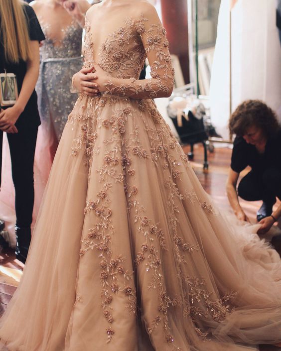 a dusty pink wedding ballgown with floral applique, embroidery and illusion sleeves plus a train is absolutely stunning