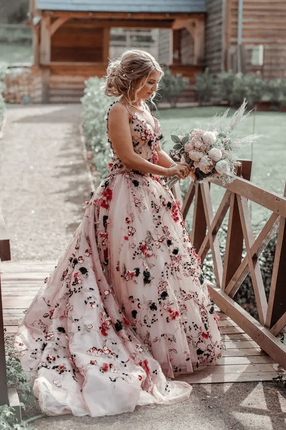 A jaw dropping blush A line wedding dress with colorful floral applique, a deep neckline and spaghetti straps plus a train