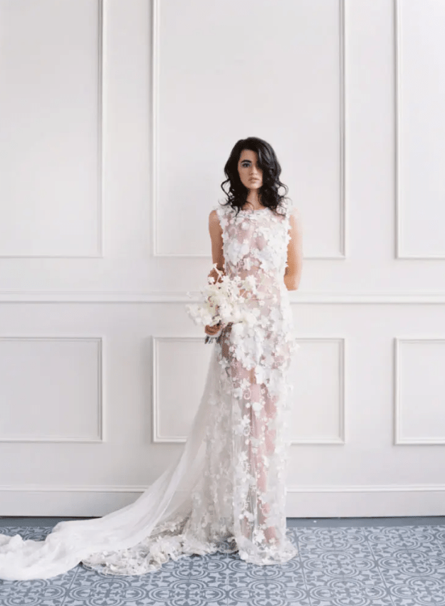 a stunning sheer wedding dress with no sleeves, fully covered with white floral appliques
