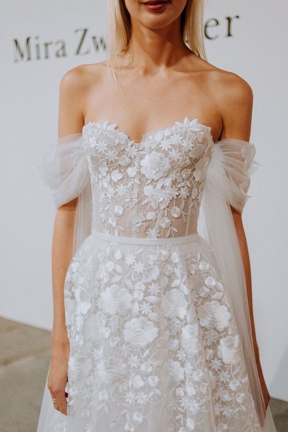 an adorable off the shoulder wedding dress with floral applique and tulle sleeves is amazing for a chic look