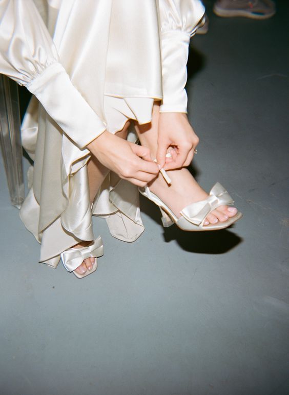 ivory satin wedding shoes with large bows are a cool addition to a silk wedding dress, they are a perfect match