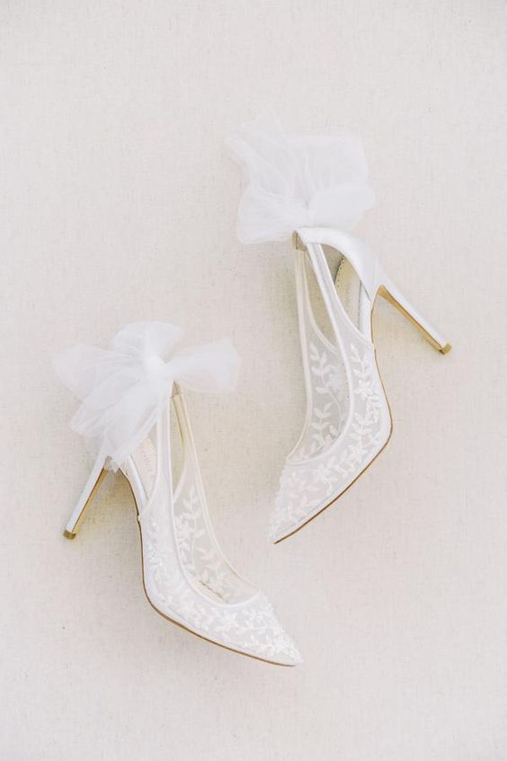 sheer white wedding shoes with cutouts and bows are a chic and delicate idea for any bride