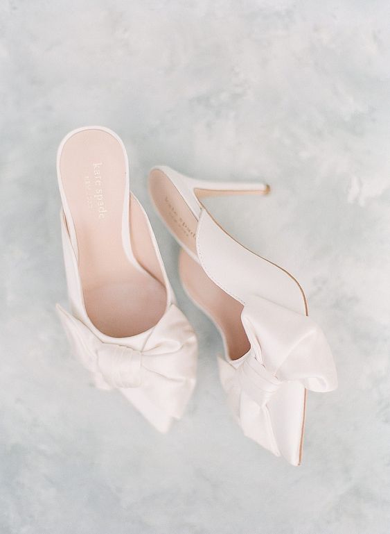 white wedding mules with bows and high heels are a chic and catchy idea for a spring or summer wedding