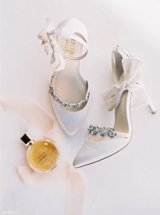 white wedding shoes with embellished straps and bows on ankle straps are super chic, glam and refined