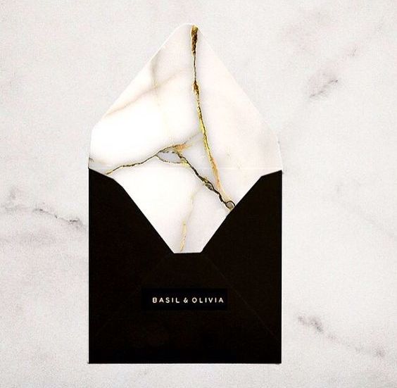 a black envelope with a marble lining with gold touches