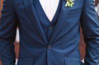 04 a navy wedding suit with a white shirt, a burgundy bow tie and a burgundy floral boutonniere