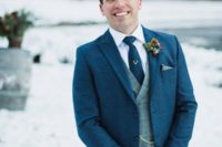 05 The groom was wearing a blue tweed suit with a grey vest and a tie, it was accessorized in winter style