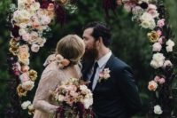 05 a moody floral wedding arch with blush roses and dark purple blooms