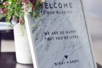 05 framed marble welcome sign with greenery and flowers on the corner
