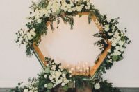 06 oversized hexagon wedding backdrop with lush greenery, candles and white blooms