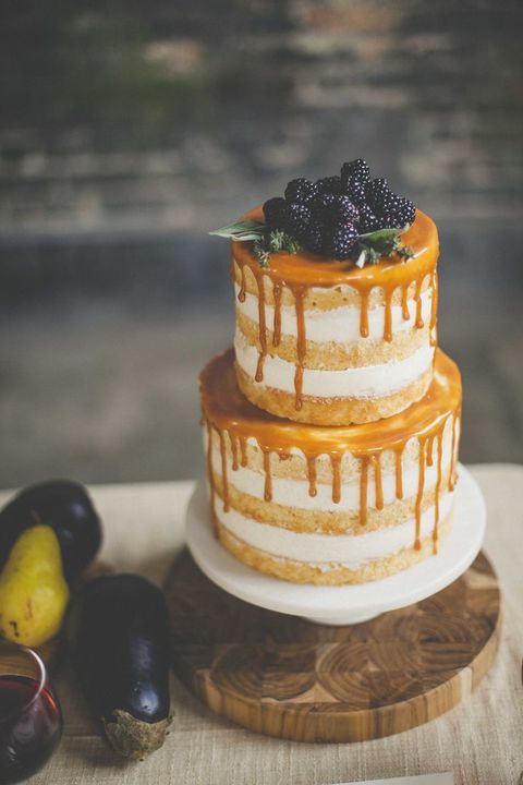 naked wedding cake with salted caramel drip and topped with blackberries