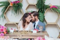 08 hexagon sweetheart table backdrop with lush greenery and bold blooms