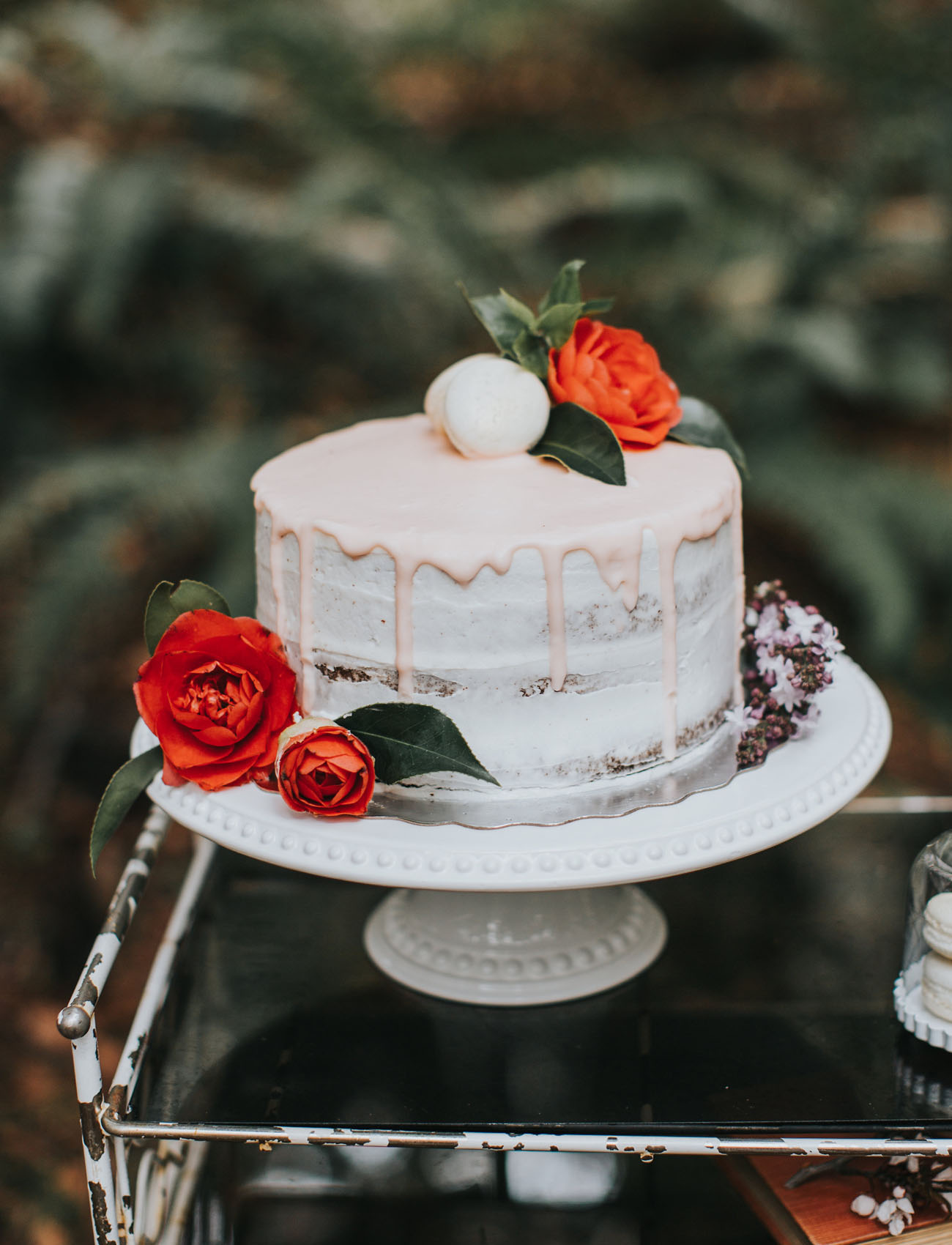 The wedding cake was a semi-naked one, with pink glazing, topped with orange blooms and macarons